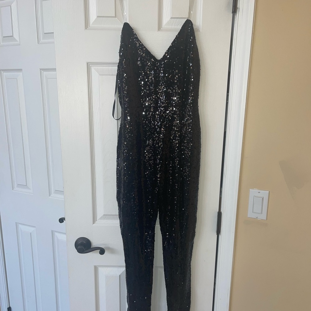 Black sequin jumpsuit with clear straps. Never worn. zipper back.